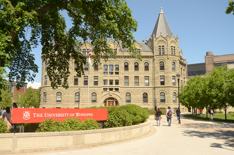 L’entrée de l’Université de Winnipeg montrant des étudiants se dirigeant vers les portes.