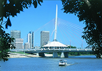 Pont décoratif au-dessus d'une rivière. Il y a une structure circulaire au milieu du pont, avec une haute colonne dépassant du milieu. Plusieurs câbles sortent de la colonne pour la soutenir.