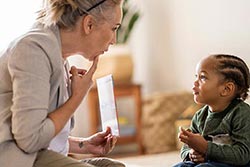 Speak language pathologist working with child