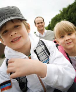 a man with children carrying backpacks smiling