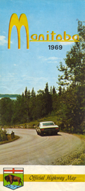 Large yellow M in Manitoba.  Car and trees, curve in background