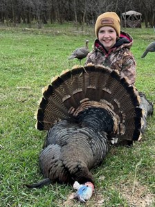 Kid holding a wild turkey